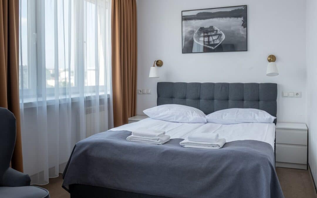 Sypialnia apartamentu z łóżkiem małżeńskim przy oknie